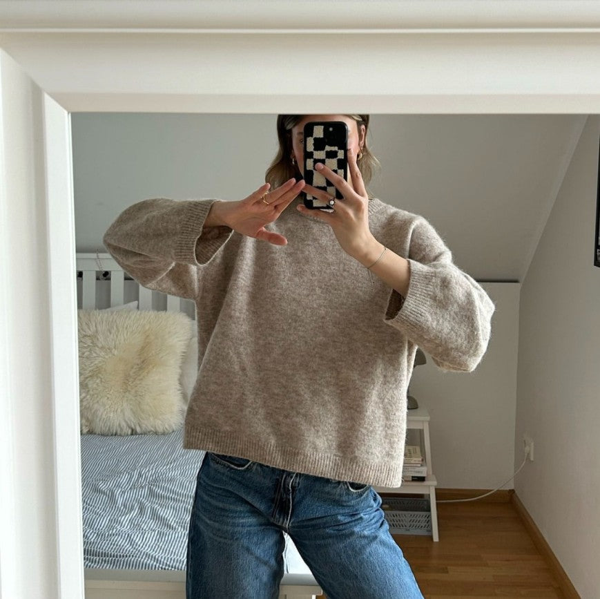 Person holding Casa Rolio Mono tufted cotton iPhone case showing slim profile and elegant design